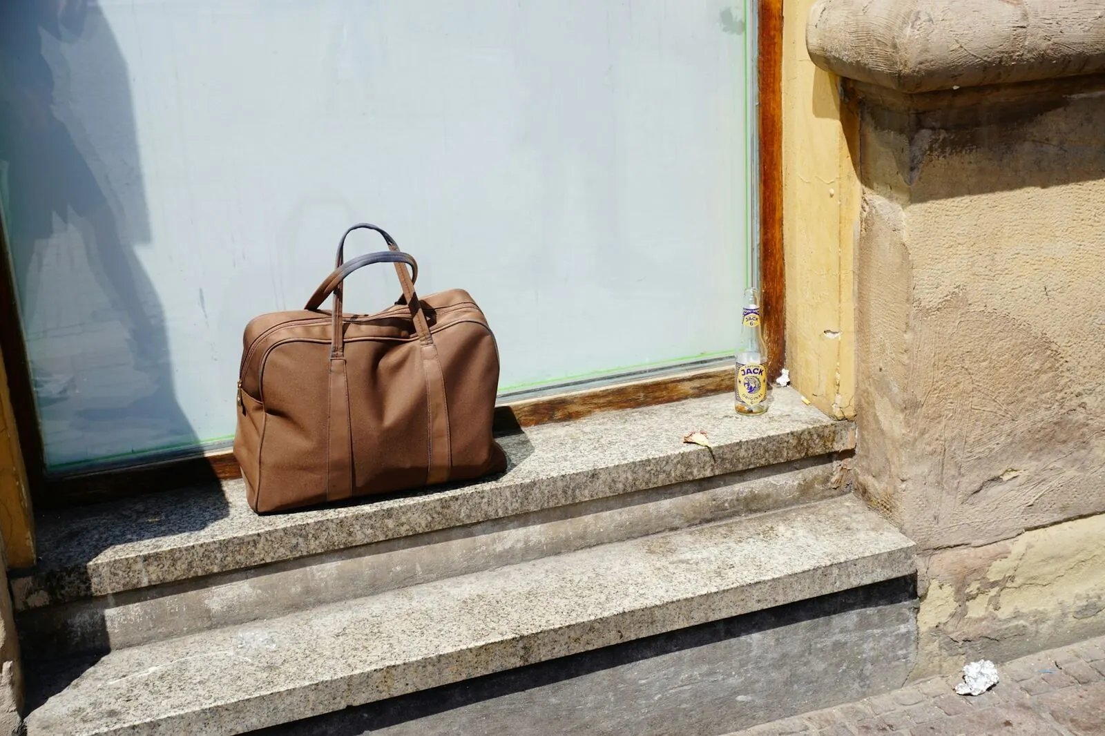 A brown travel bag on stone steps
