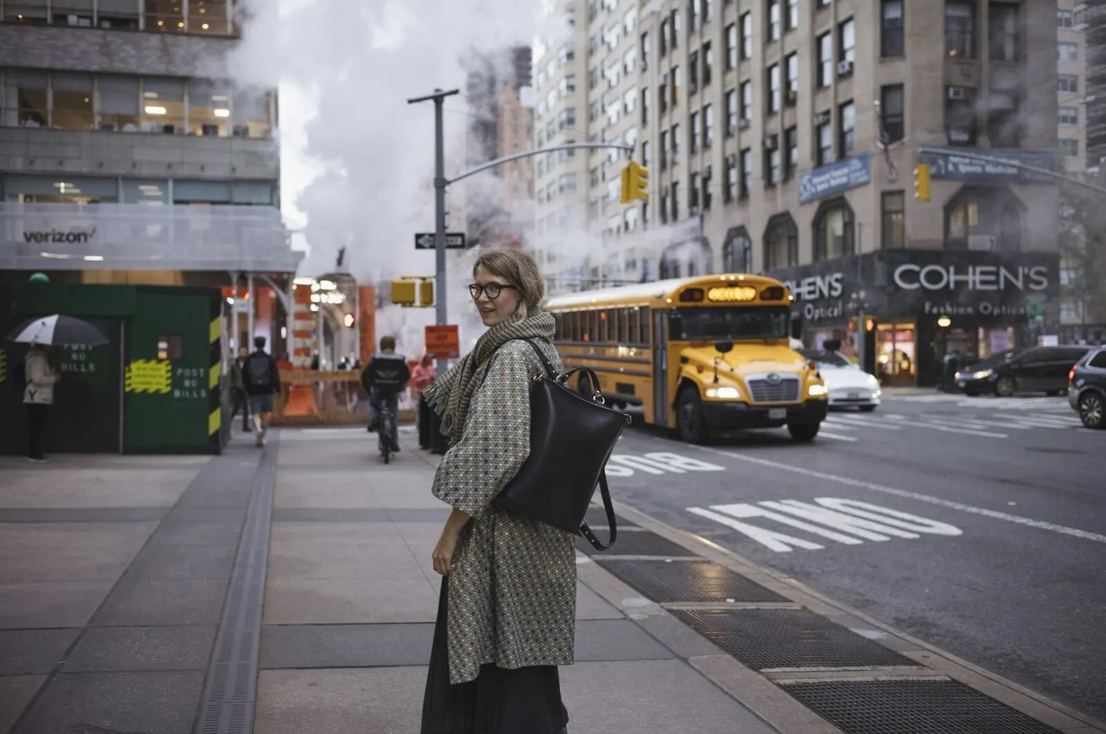 A commuter with a shoulder bag on a city pavement