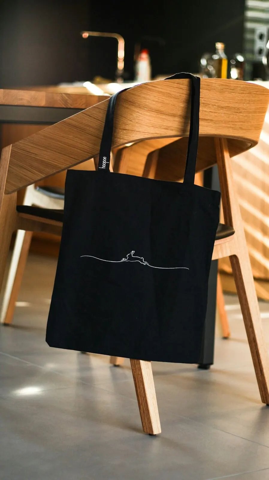 Black leather tote bag held by its handles